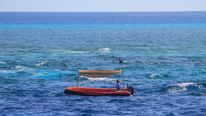 A small boat is at the surface in choppy seas