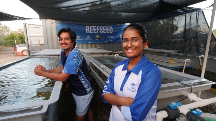 two people smiling at camera among large aquaria