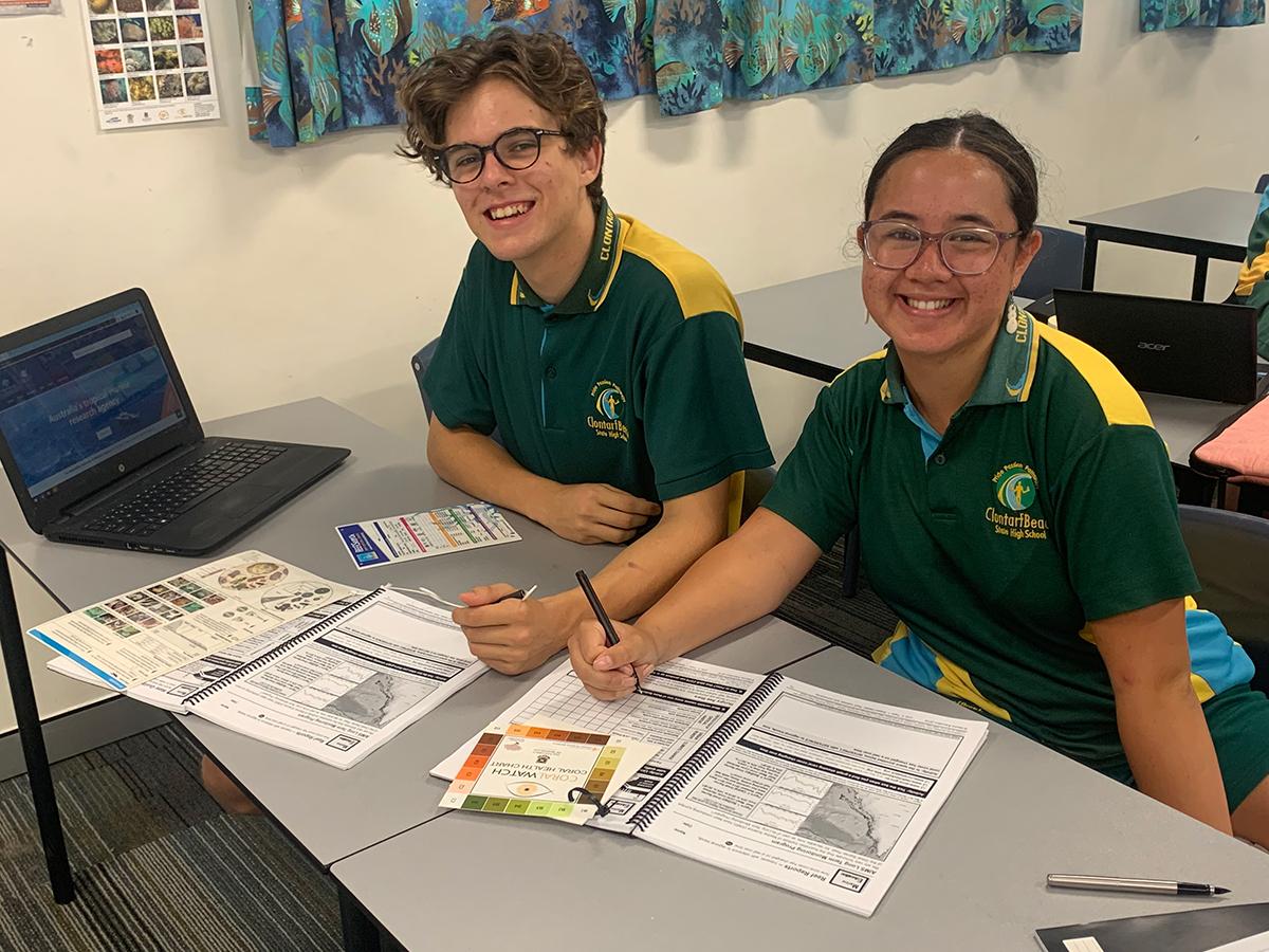 two students happy about working with marine science workbook