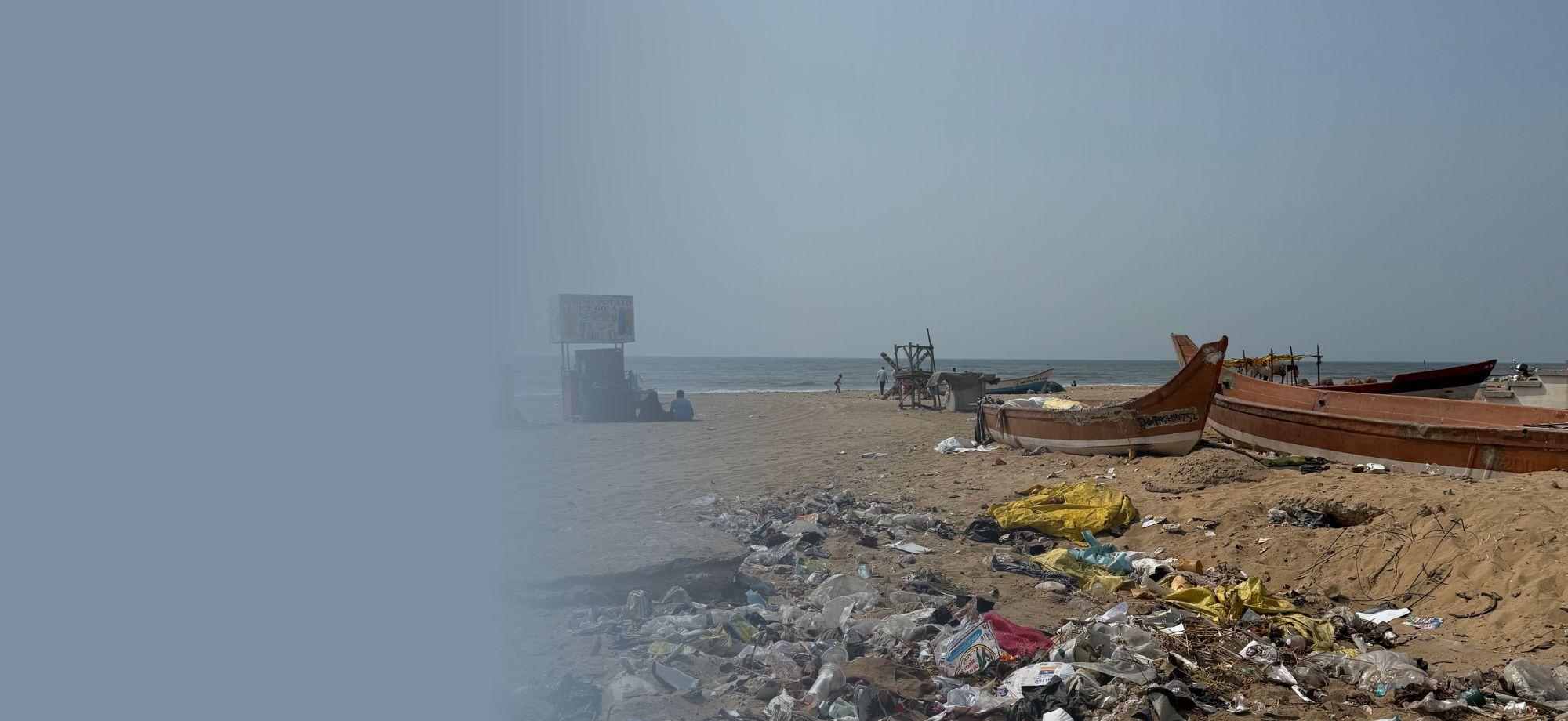 a beach with boats on it. rubbish of different types is also on the beach