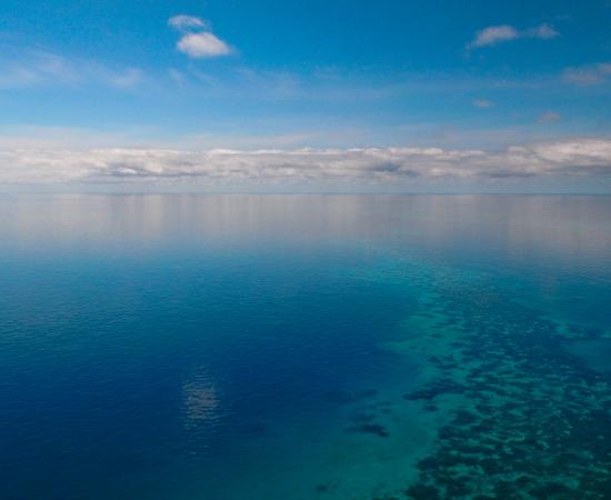 a sky with white clouds meets a calm sea